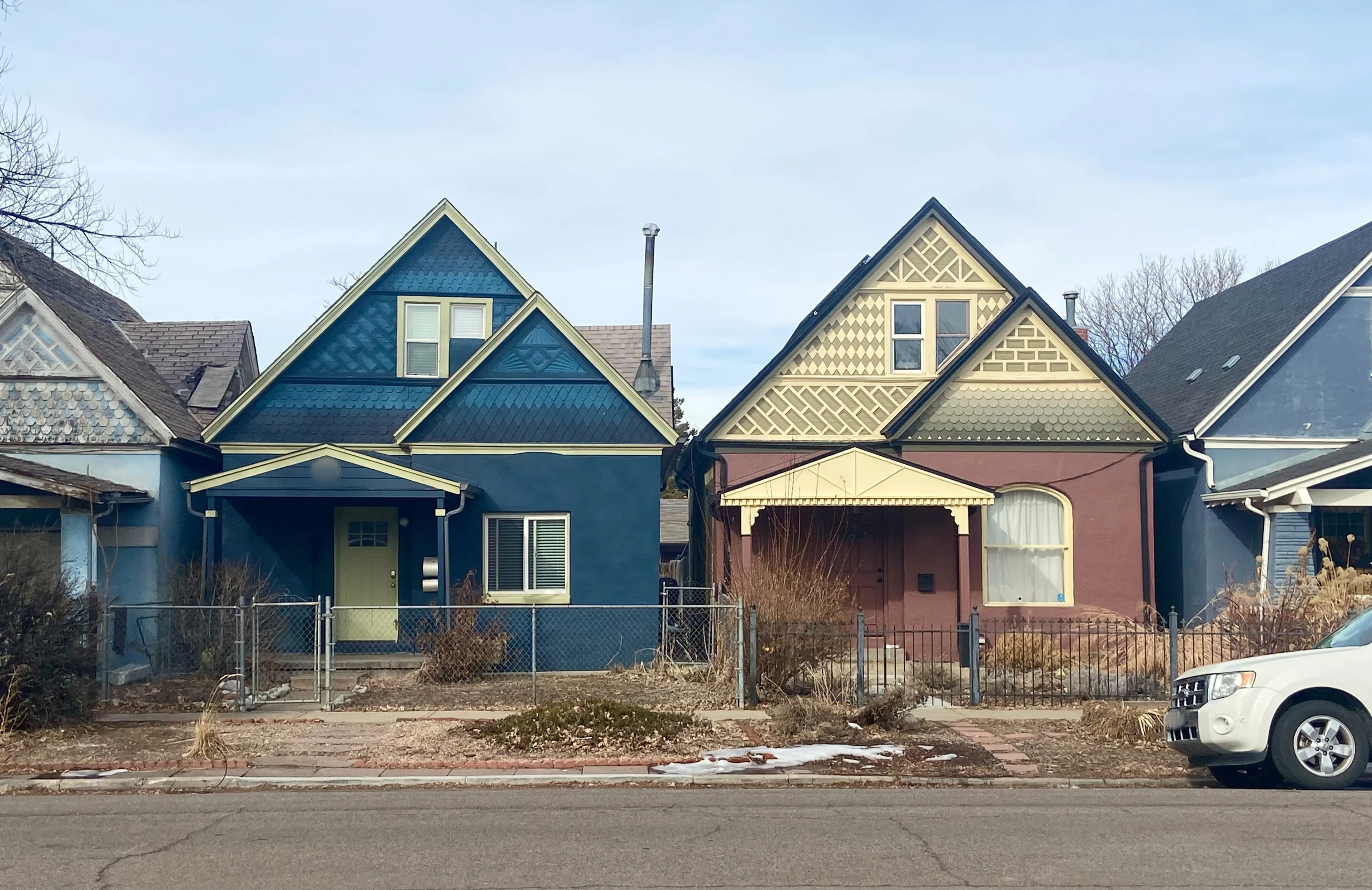 Two colorful Victorian homes side by side on a winter day in Denver’s Whittier neighborhood