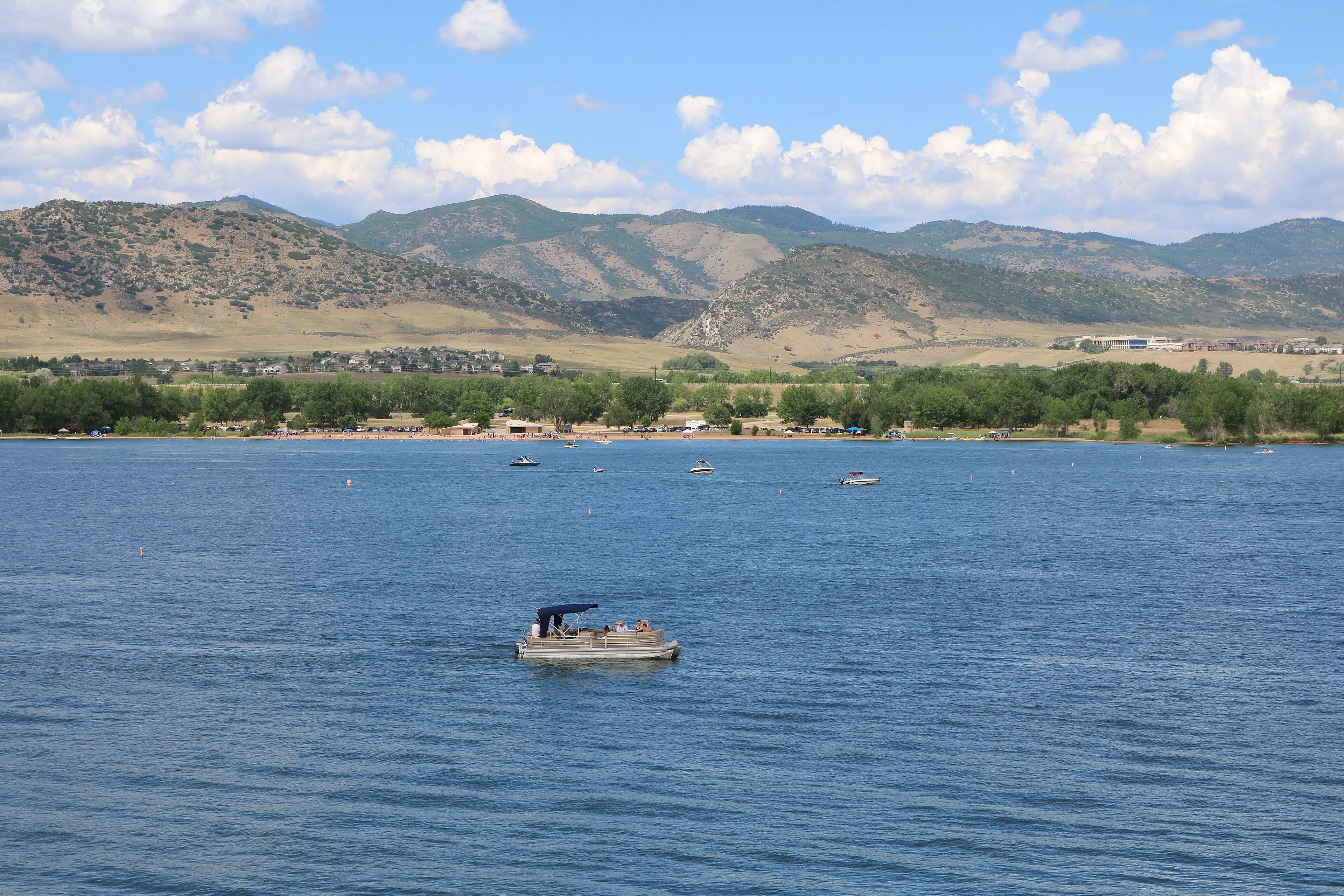 Chatfield Reservoir with a pontoon boat and the Dakota Hogback foothills beyond